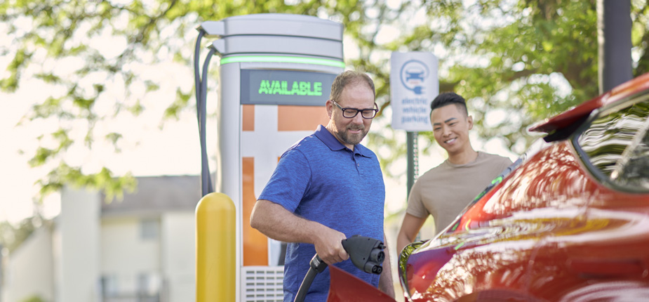 Two men at a DC fast charging station charging their EV